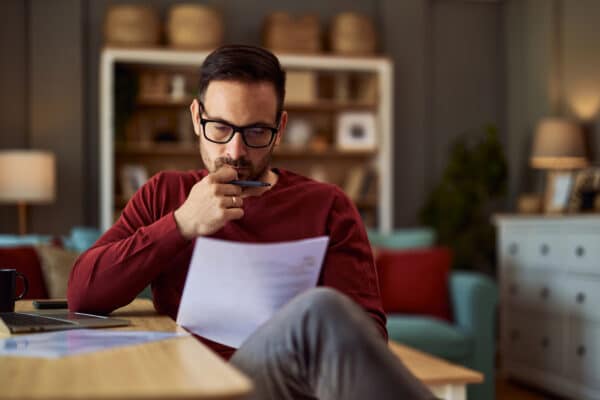 Zakenman achter laptop, die zich ook focust op een document